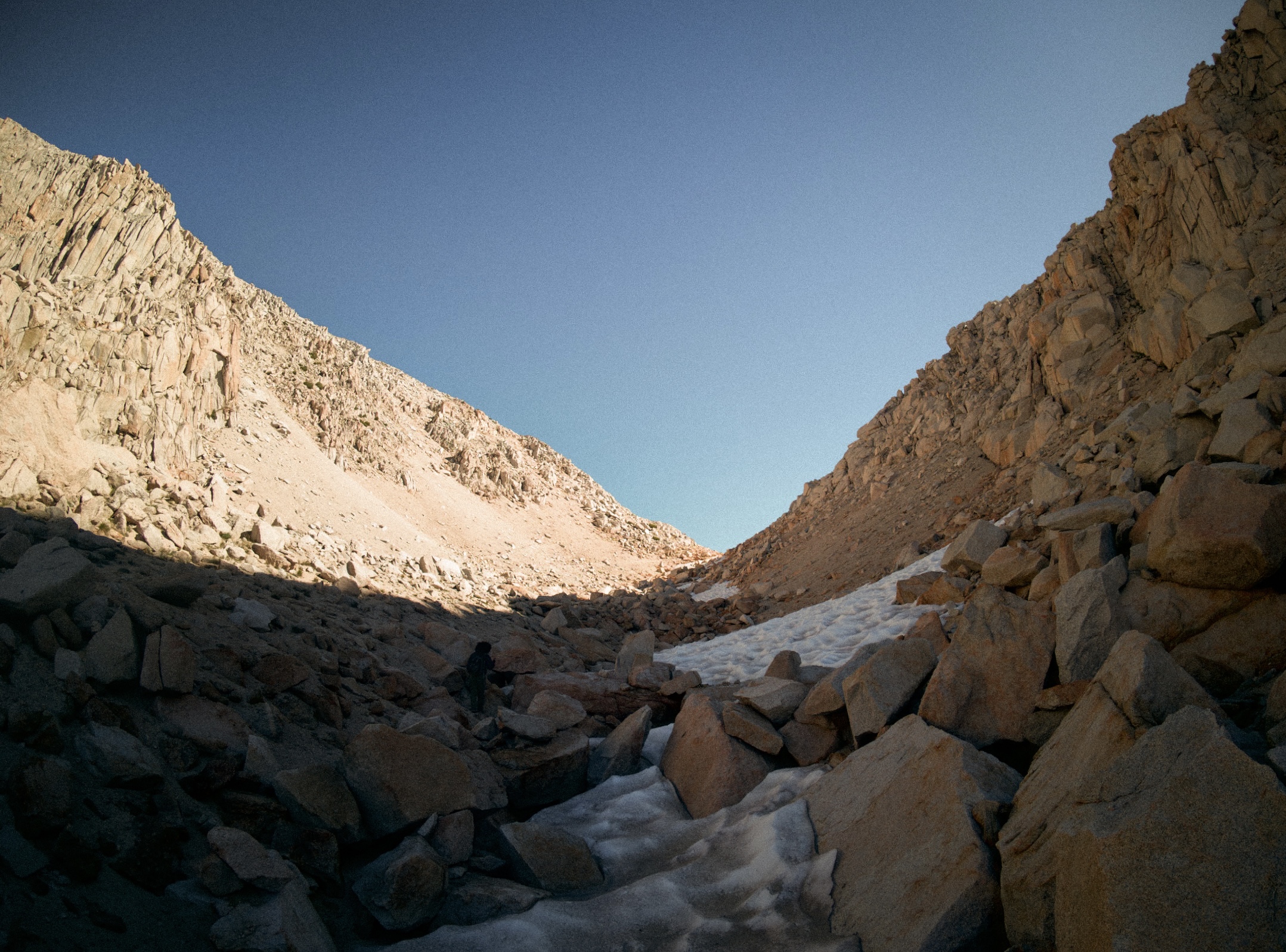 Hiker standing on snow-covered Mono Pass on the John Muir Trail, Brayden Noh